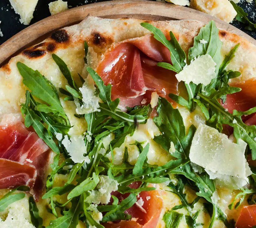 Pizza with procuito, arugula and parmesan